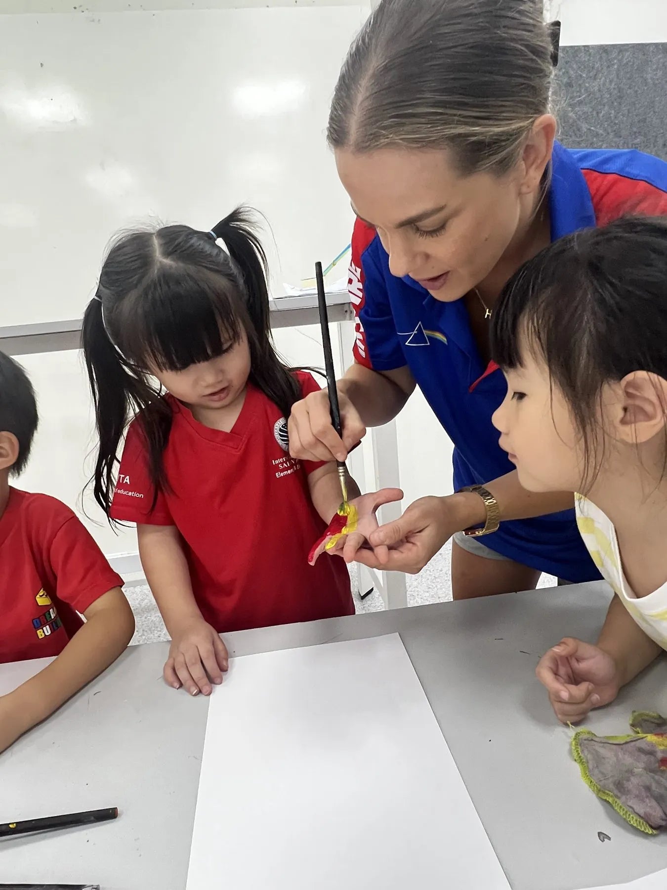 A Group Leader painting with young campers